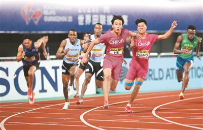 中国队选手王胜杰（右二）和何锦櫶（右三）在4×100米接力资格赛比赛中交接棒。新华社记者 李明摄
