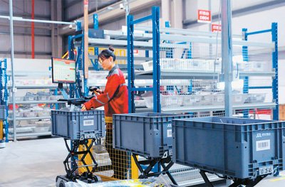 京东物流智狼搬运机器人将对应订单的商品送到工作站。本版照片除署名外，均为受访企业供图