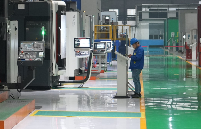 沈鼓集团转子车间里，技术工人在屏幕上布置任务，身边的数控机床开始精雕细刻。人民网记者 周颂雪摄