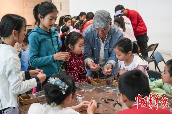 　　5月4日，中国非物质文化遗产馆举办的研学活动中，孩子们在制作草编蜻蜓冰箱贴。中青报·中青网见习记者 陈宇龙/摄