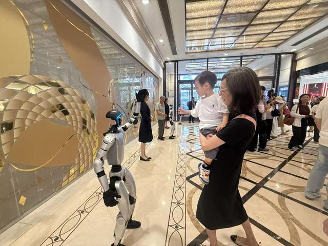 消费者与宇树机器人打招呼。 文汇报记者 徐晶卉摄