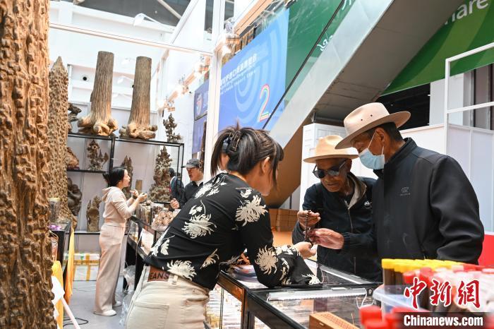 图为拉萨进口商品展览会现场，越南商人(左)向顾客介绍、推销佛珠。中新社记者 贡嘎来松 摄
