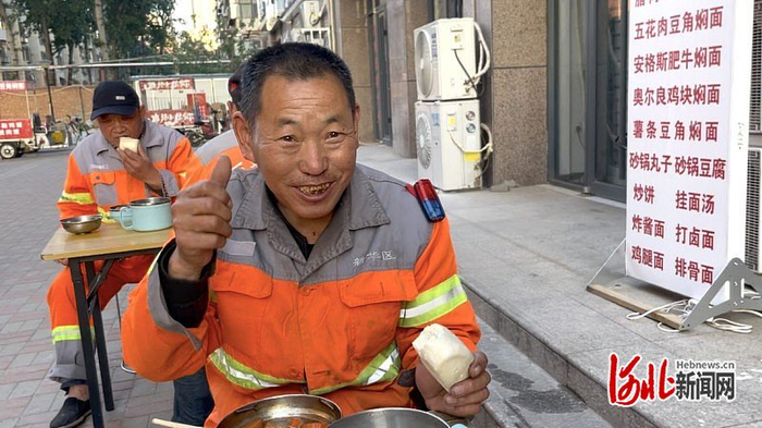 一位前来吃饭的环卫工为这家餐厅和志愿者竖起了大拇指。（尹春月/摄）