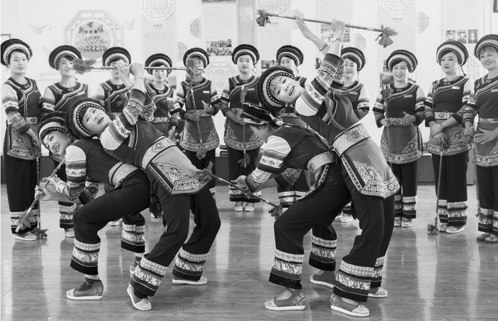     上图：在洱源县右所镇幸福村，李六妹（左二）向斯甘俏艺术团的演员传授霸王鞭技艺。