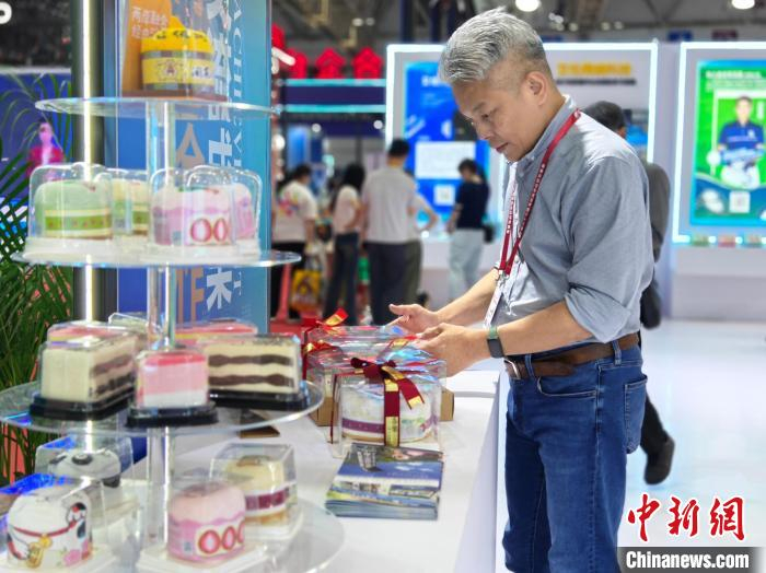 　　5月18日，在第二十七届海峡两岸经贸交易会上，台胞林颖穗忙着整理蛋糕毛巾。叶秋云 摄