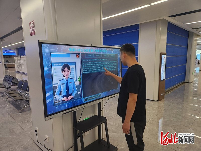 5月12日，在张家口市政务服务中心二楼办事大厅，市民向数字人警察咨询办事流程。赵新琼摄