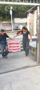 黄昕月（右）和工友一起搬运水泥。受访者供图