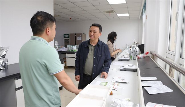 韦勇（左二）在贵州省江口县贵茶产业园产品研发办公室与同事探讨产品特性（5月14日摄）。