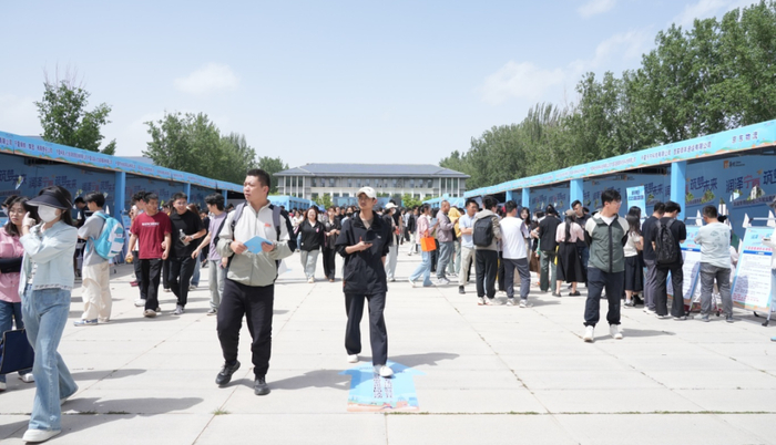 活动现场，应聘者手持简历，穿梭于各展位之间，寻找合适岗位。