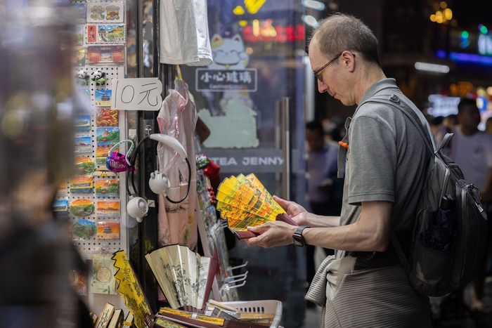 5月16日，什刹海，外国游客在挑选中国折扇。