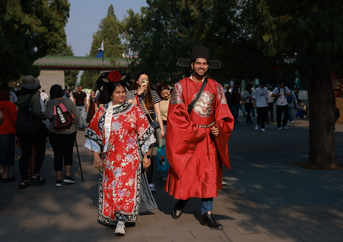5月10日，天坛东门，印度裔新加坡青年Thane和新婚妻子Sharon穿着红色古装在天坛公园中漫步。