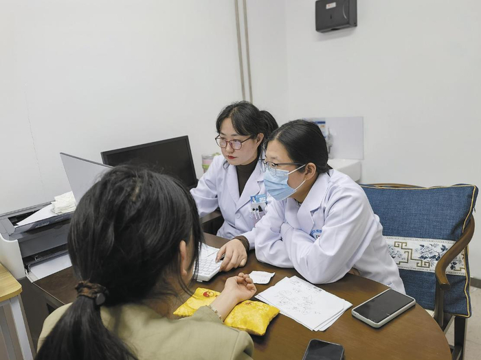 王晨晔（右一）和同事苏蕾交流治疗思路。咸文静 摄