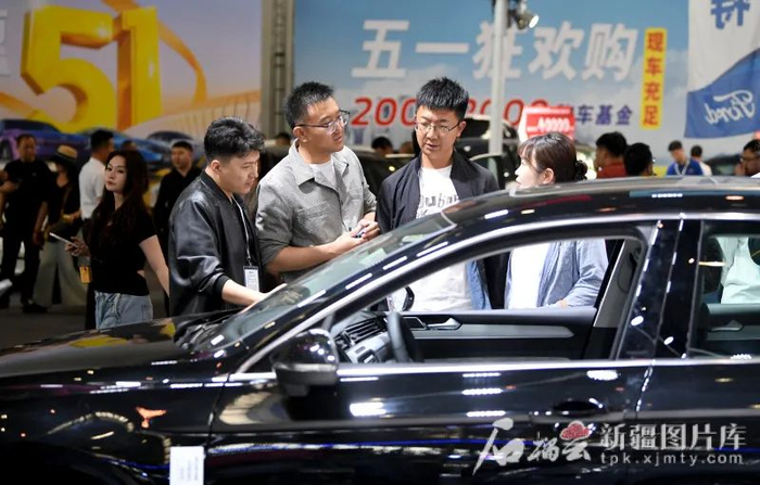 5月1日，市民在第十三届新疆五一国际车展上了解汽车性能