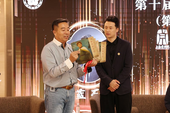 5月7日，戏迷潘月斌拿着“祖传”1970年版《智取威虎山》唱片请主演蓝天签名。本报记者 赖鑫琳 摄