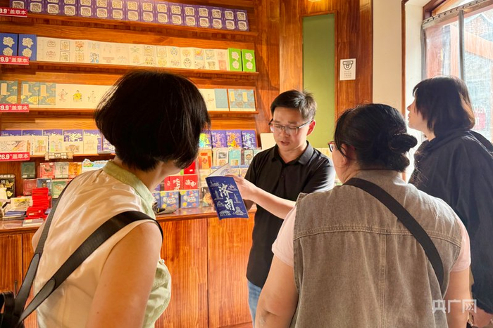 翟风平在店内向消费者介绍原创印章（央广网记者  李舜  摄）