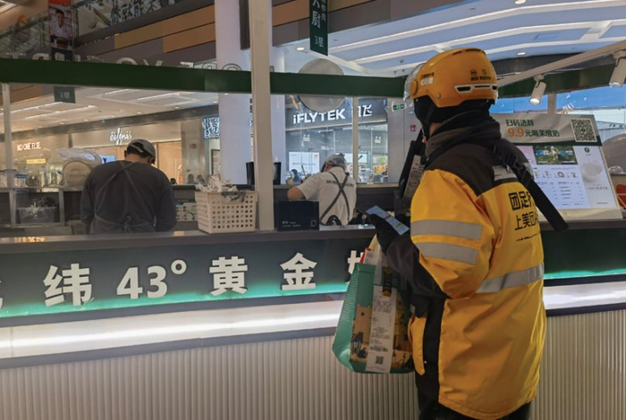 　　图为正在等候取餐的外卖员。