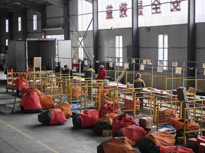门源县物流仓储分拨配送中心内工作人员正在分拣包裹（记者江晓晨  摄）