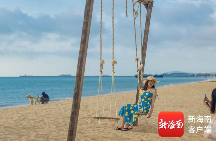 市民游客在荣山寮海滩上的秋千拍照。记者 刘孙谋 摄