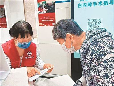 图为医务社工为老年患者梳理检查单。