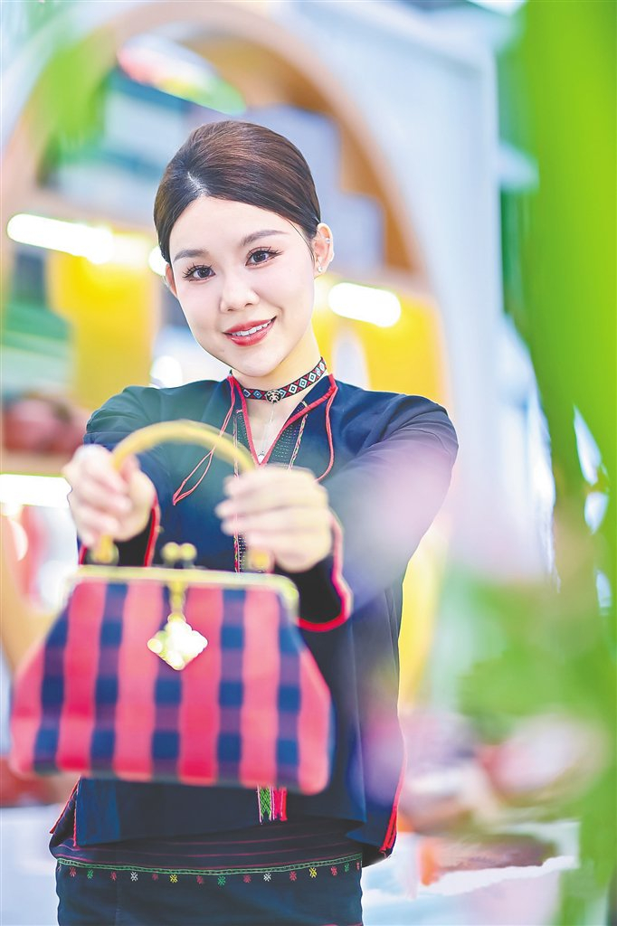 展馆的工作人员展示黎锦包包。