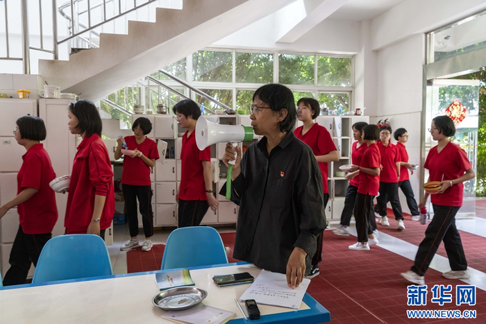 华坪女高食堂，张桂梅拿着小喇叭催促学生们吃饭（资料图）。（新华社 陈欣波 摄）