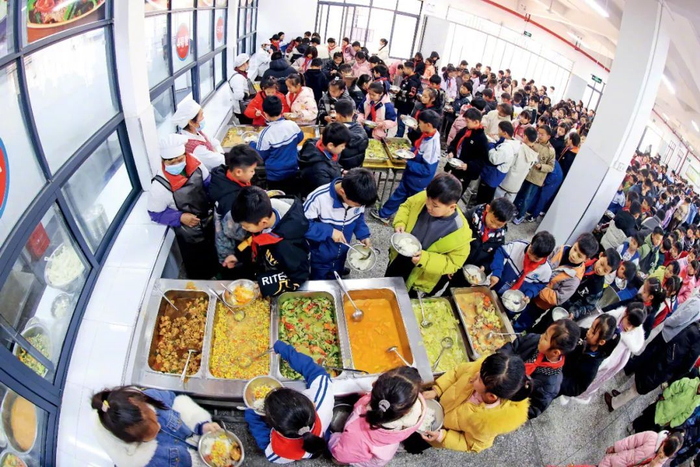 2025年2月17日，广西柳州融安县浮石镇中心小学食堂，学生们在排队打饭菜。