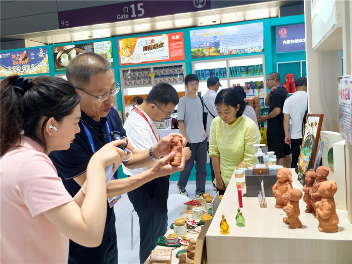 媒体记者采访乌达黄河泥娃制作过程。