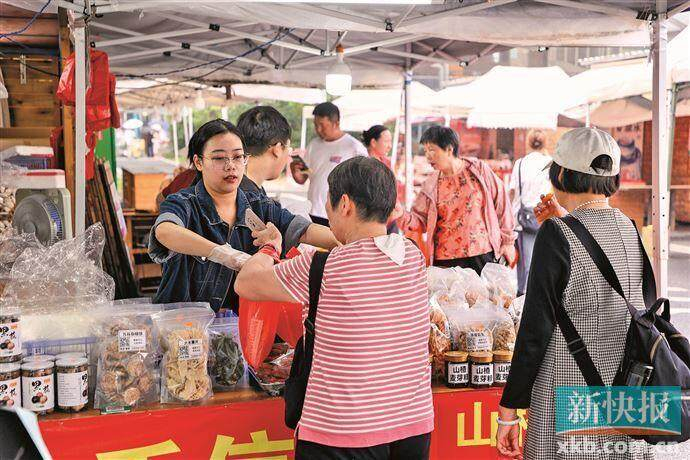 ■塘口墟集市上，不少游客在购买当地手信。