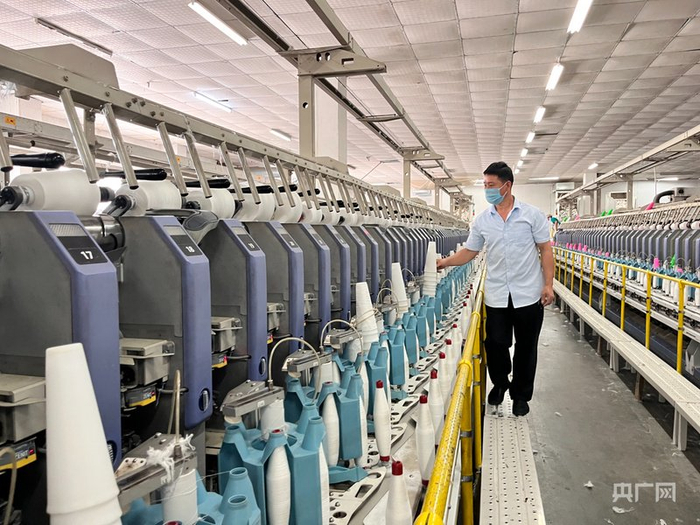 车间工人检查自动化纺织设备（央广网记者  陈锵  摄）