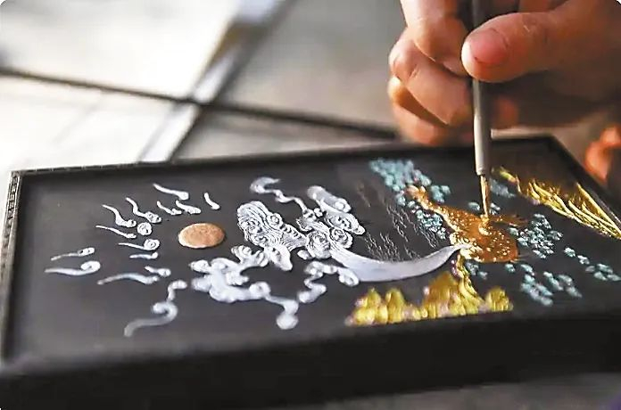 ▲ 安徽歙县“项氏徽墨”的工人为晾干的墨进行描金。新华社发