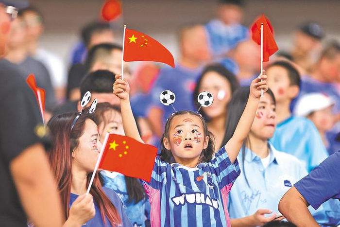 小球迷挥舞五星红旗为武汉队加油。