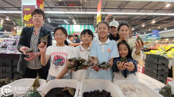 台胞小朋友在活动现场包粽子并合影留念。（中国台湾网发）