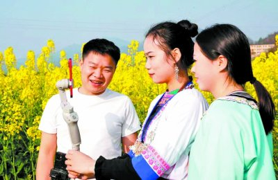     返乡创业青年唐胜忠（左一）在榕江县车江大坝给新媒体人员传授直播技巧。王炳真/摄
