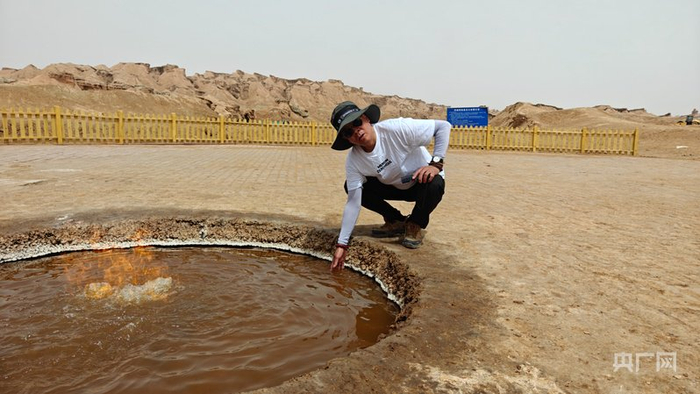 游客感受烈焰泉内的水  （央广网记者郭璁悦  摄）