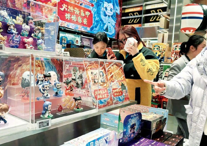 2月17日，消费者在北京一家泡泡玛特店选购哪吒、敖丙等手办人偶。图/视觉中国