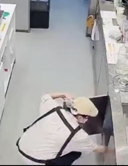 视频截图，一名店员藏起刀具