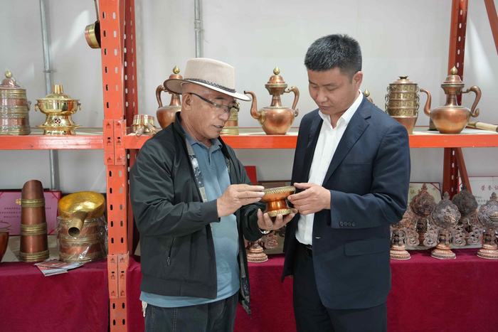 图为工商银行工作人员与夏河县善源民族工艺品有限公司负责人交流