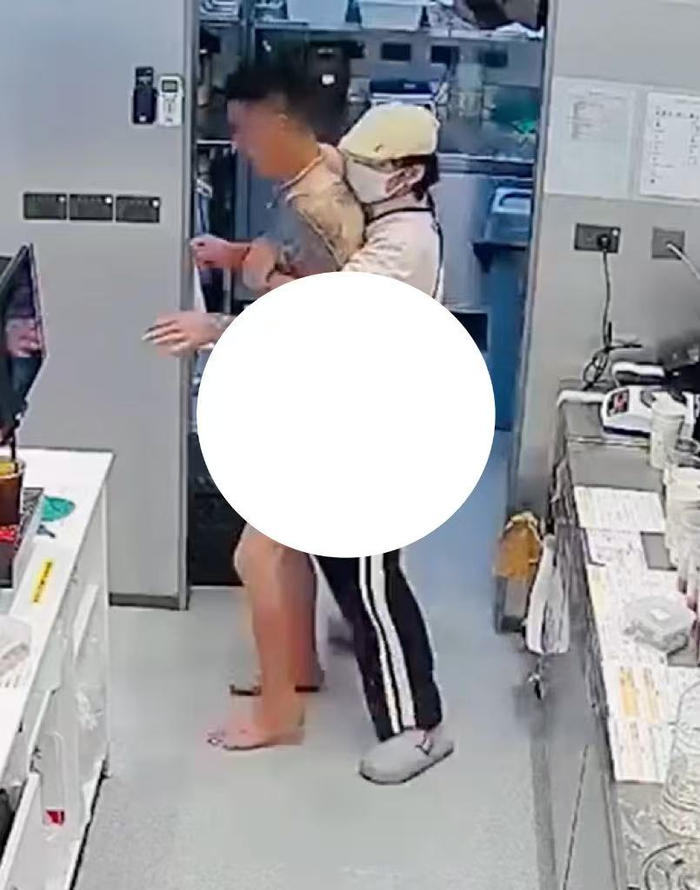 视频截图，一名店员控制住该男子