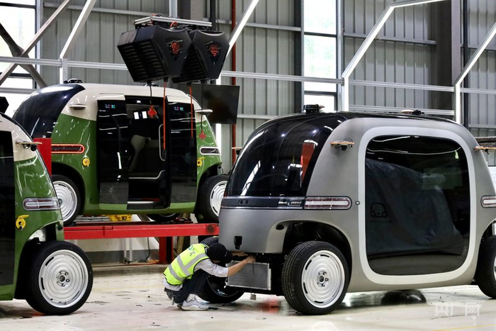 数字制造工厂内，技术人员正在组装无人驾驶小巴（央广网记者  杨贇  摄）