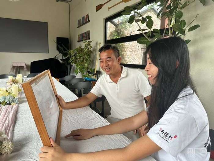 陈家欣和陈啟光在“感谢海报”前回忆跨文化交流的美好瞬间（记者韩雪莹  摄）