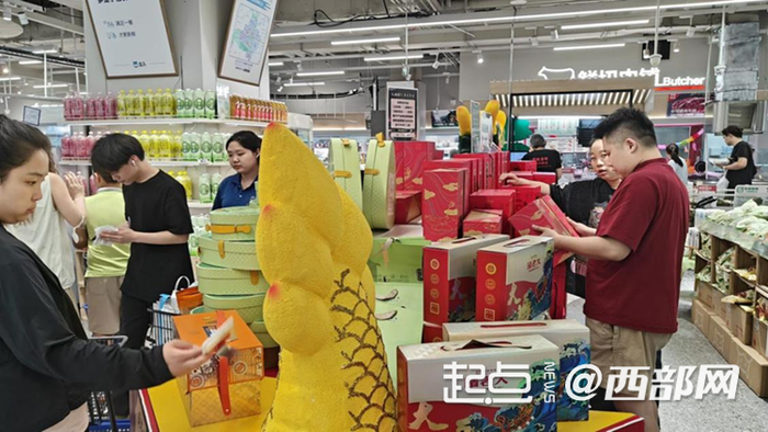 顾客在超市挑选粽子礼盒。