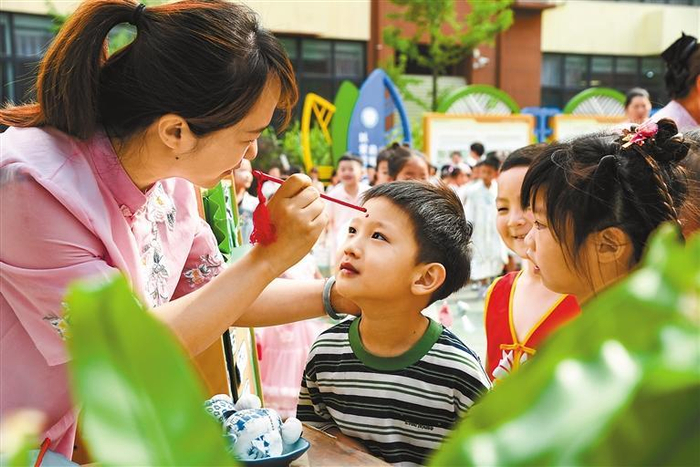     5月30日，在河南省济源市愚公路幼儿园，老师为小朋友点朱砂。新华社发（苗秋闹 摄）