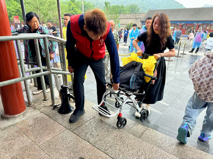 景区工作人员帮助推车旅客上台阶。八达岭文旅集团供图
