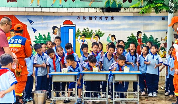 在思茅港镇橄榄坝小学，消防员组织学生开展“四渡赤水”游戏。图片来源于新华网