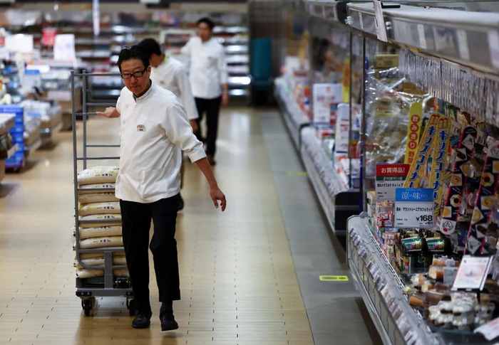 5月31日，在日本东京的一家超市，店员搬运储备米/图源：新华社