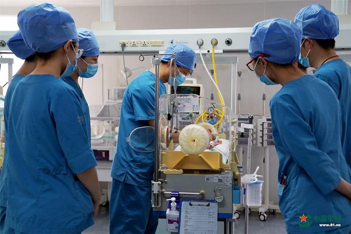 　　新生儿科医护人员在保温箱前观察新生儿状态。中国军网记者孙悦 摄
