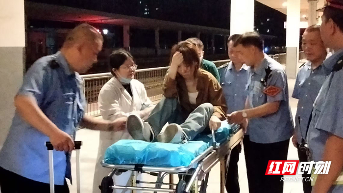 工作人员与医务人员一起将旅客扶上担架，及时送医。