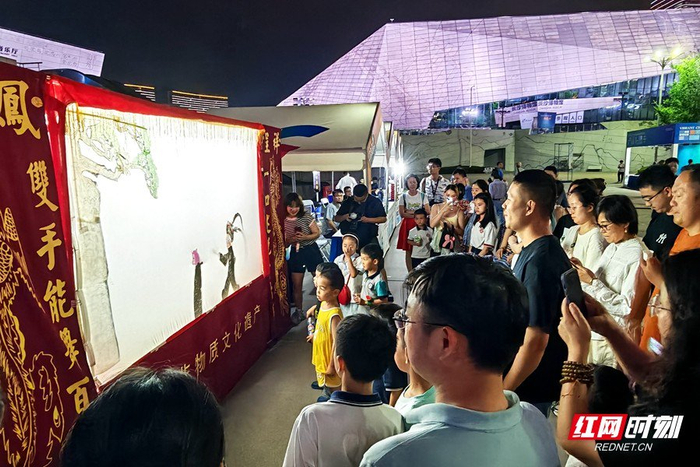 精彩的皮影戏表演吸引了游客们驻足观看。