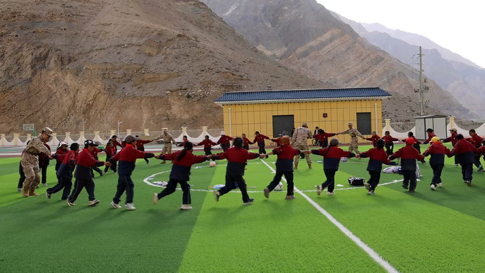 图为官兵和孩子们一起快乐地玩游戏。记者 王香香 摄