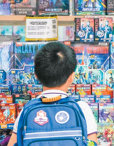 在江苏南京市一小学附近的文具店，一名小学生选购卡牌盲盒。新华社记者 李博摄
